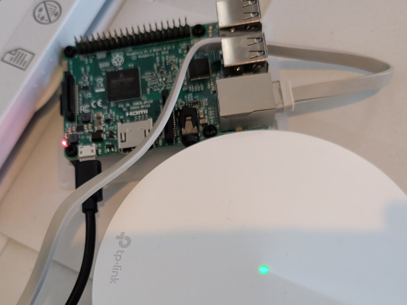 Raspberry Pi 3 Model B running headless on a shelf, powered over micro USB and wired to a TP-Link mesh access point